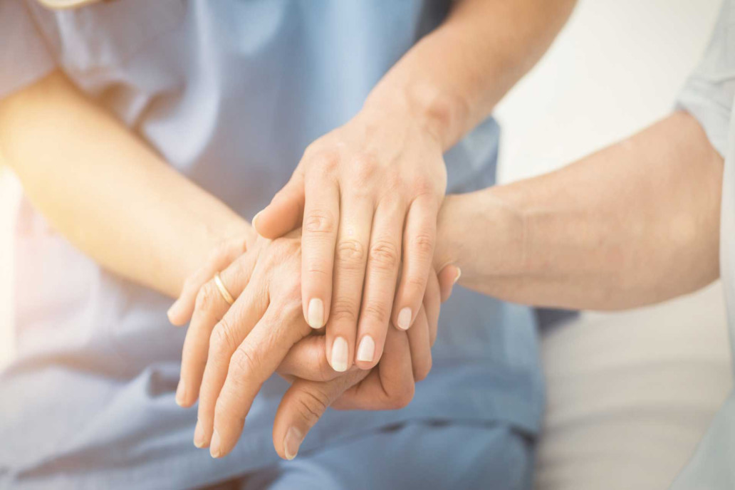 nurse holding patients hand crisis care nursing care Endless Journey Hospice Omaha Nebraska