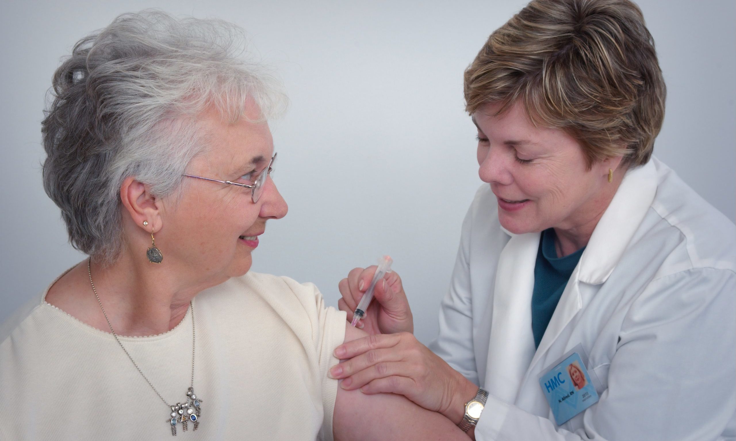 Nurse giving elderly patient shot our care nursing care Endless Journey Hospice Omaha Nebraska