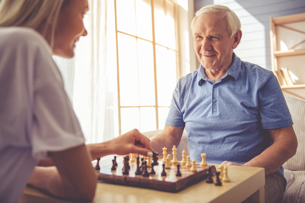 we salute you volunteer playing chess with client geriatric volunteer manager Our care volunteer program Endless Journey Hospice Omaha Nebraska active duty